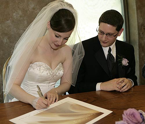 Jonathan and Nicole signing their ketubah